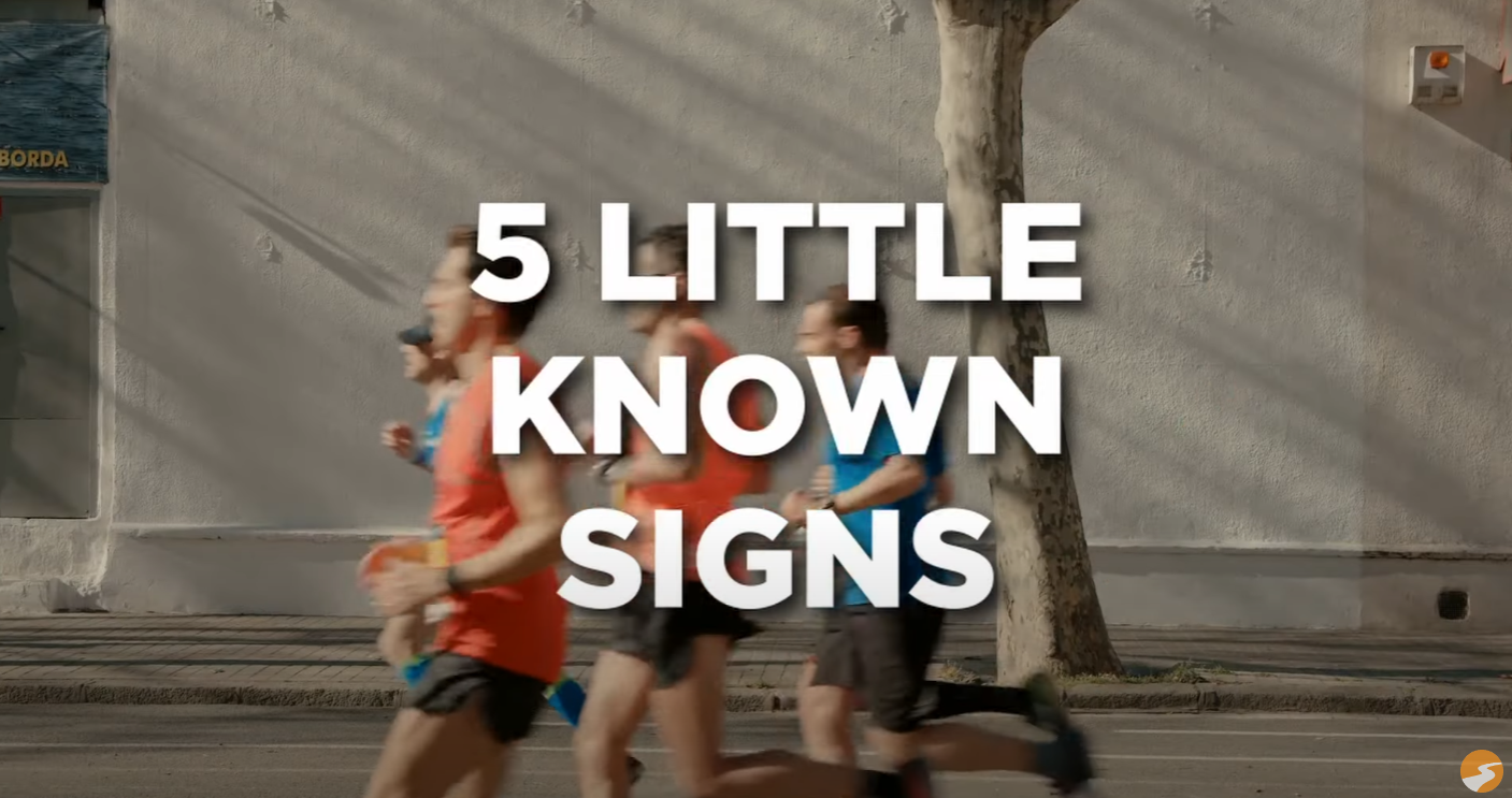 Four runners, two in blue and two in orange, running down the street